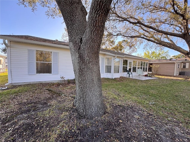 exterior space with a patio area, central AC unit, a sunroom, and a yard