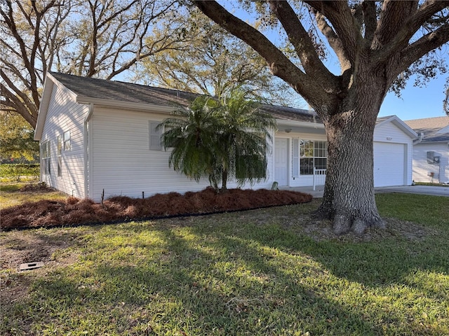 view of side of home with a garage, driveway, and a yard