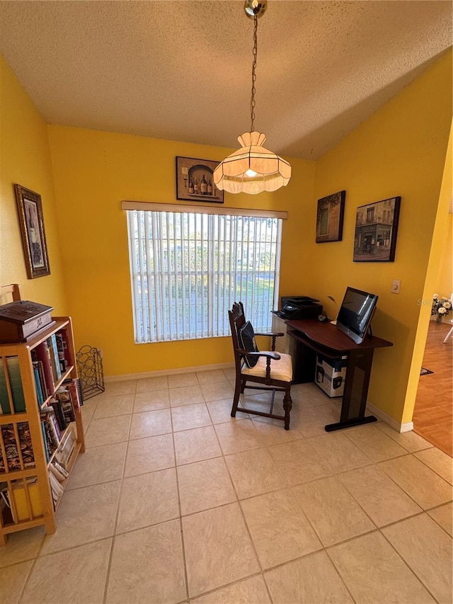 office area featuring lofted ceiling, light tile patterned flooring, a textured ceiling, and baseboards