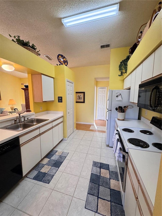 kitchen featuring black appliances, light countertops, a sink, and white cabinetry