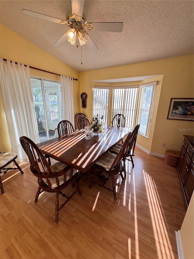 dining area with lofted ceiling, light wood-style floors, and plenty of natural light