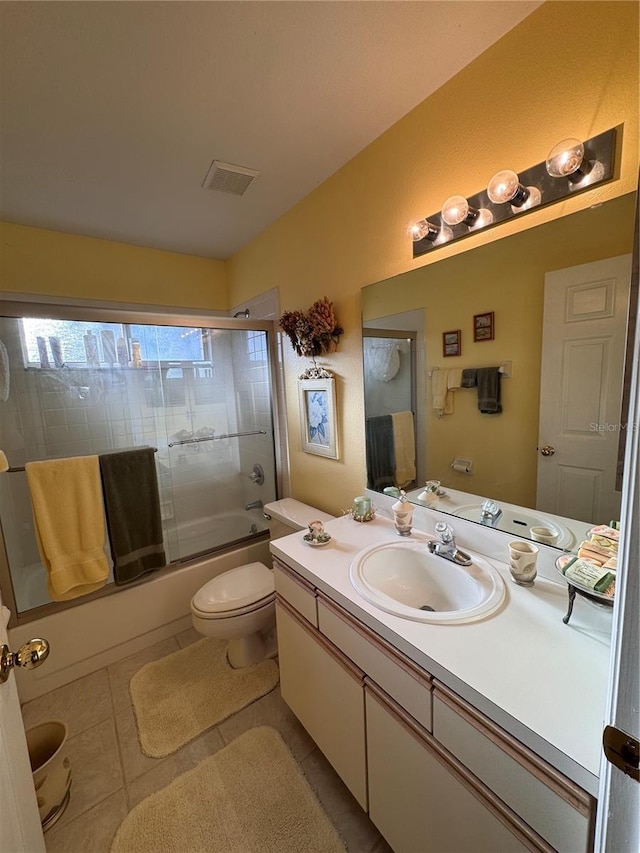 bathroom with shower / bath combination with glass door, visible vents, toilet, vanity, and tile patterned flooring