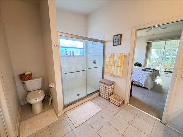 ensuite bathroom featuring toilet, a stall shower, connected bathroom, baseboards, and tile patterned floors