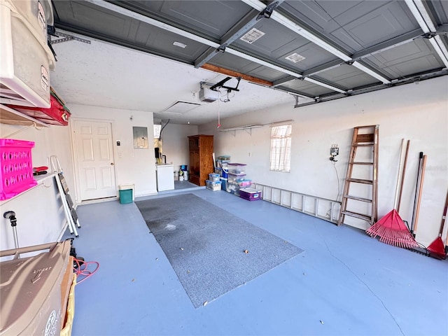 garage with electric panel and a garage door opener