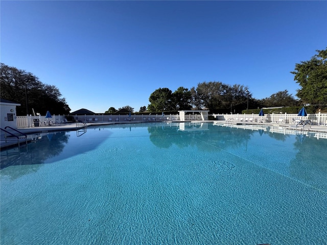 community pool with fence and a patio