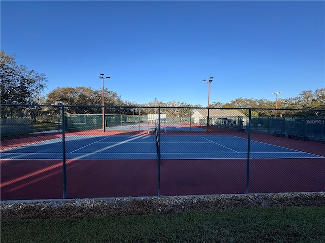 view of tennis court featuring fence