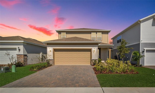 view of front of home with stone siding, decorative driveway, an attached garage, and stucco siding