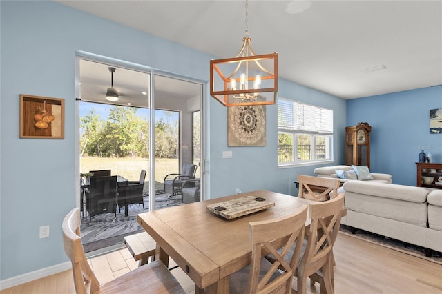 dining room featuring baseboards, an inviting chandelier, and light wood-style floors