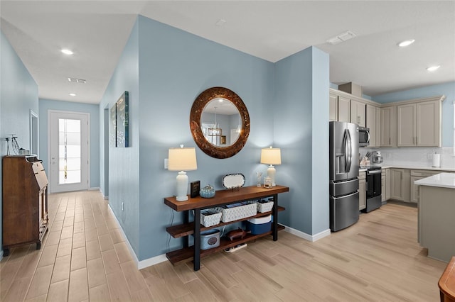 kitchen with stainless steel appliances, visible vents, baseboards, light wood-style floors, and light countertops