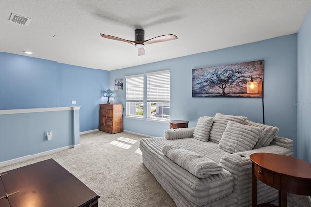 living area featuring baseboards, visible vents, ceiling fan, a textured ceiling, and carpet flooring