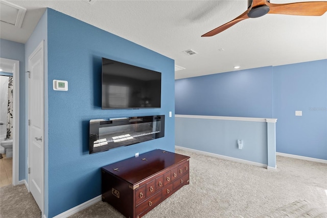 carpeted living area featuring ceiling fan, visible vents, baseboards, and a textured ceiling