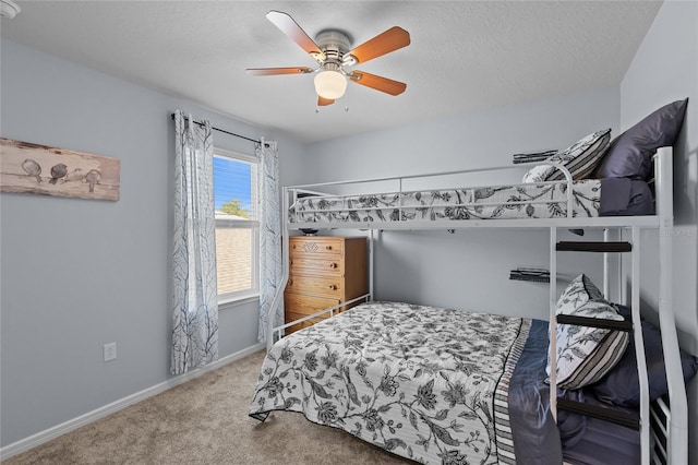 bedroom with a ceiling fan, carpet, baseboards, and a textured ceiling