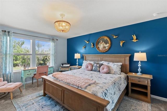 bedroom with carpet, an inviting chandelier, and baseboards