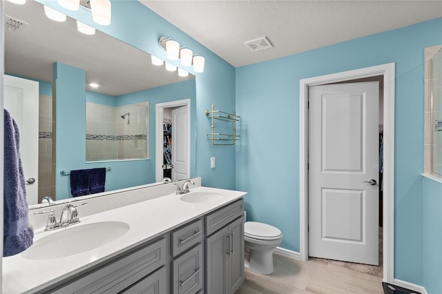 bathroom featuring visible vents, a sink, and wood finished floors