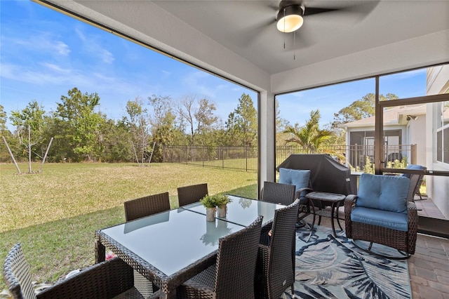 sunroom / solarium featuring a ceiling fan