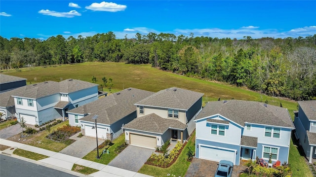 birds eye view of property featuring a residential view and a wooded view