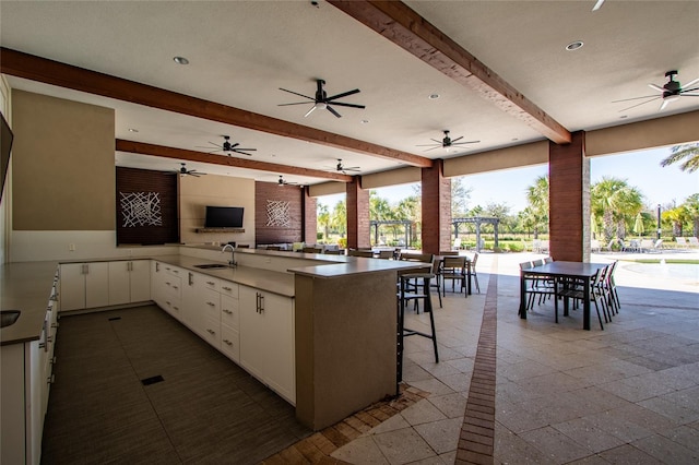 kitchen with open floor plan, a peninsula, a wealth of natural light, and white cabinetry