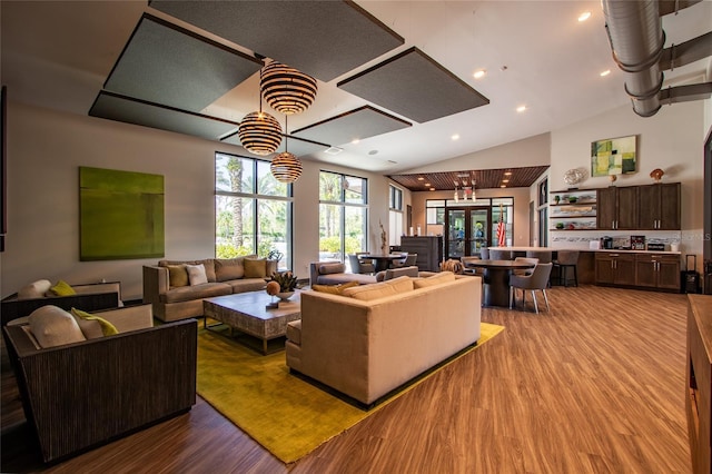 living area with recessed lighting, french doors, lofted ceiling, and wood finished floors