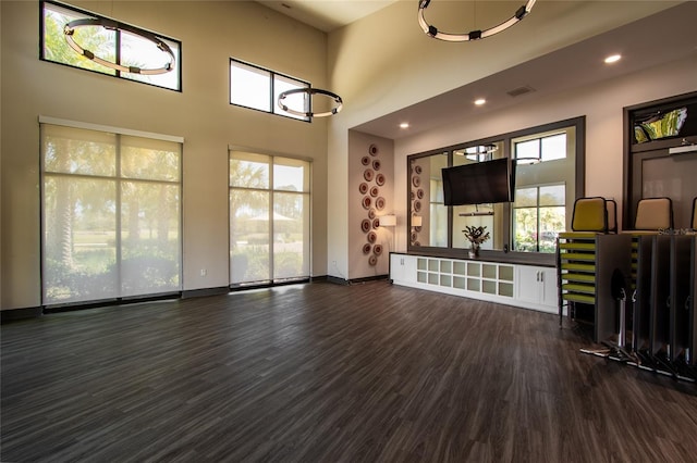 unfurnished living room with recessed lighting, wood finished floors, visible vents, and baseboards