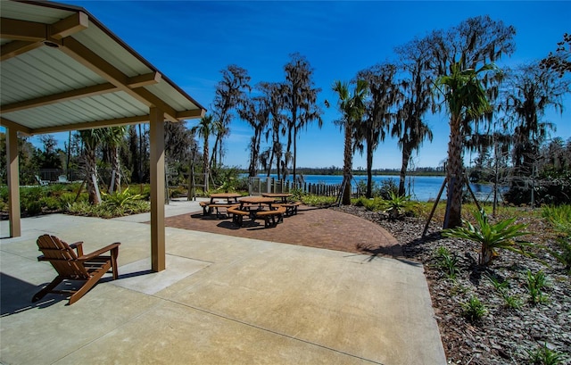 view of patio with a water view and fence