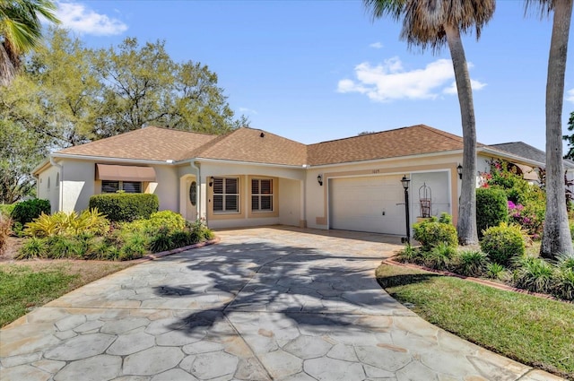 single story home with driveway, a shingled roof, an attached garage, and stucco siding