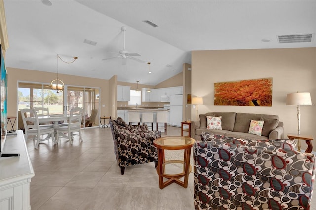 living room featuring lofted ceiling, visible vents, and a ceiling fan