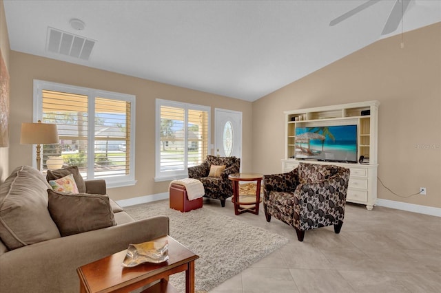 living area featuring light tile patterned flooring, a ceiling fan, visible vents, vaulted ceiling, and baseboards