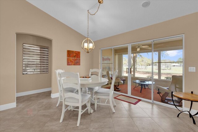 dining room featuring ceiling fan with notable chandelier, lofted ceiling, baseboards, and light tile patterned floors