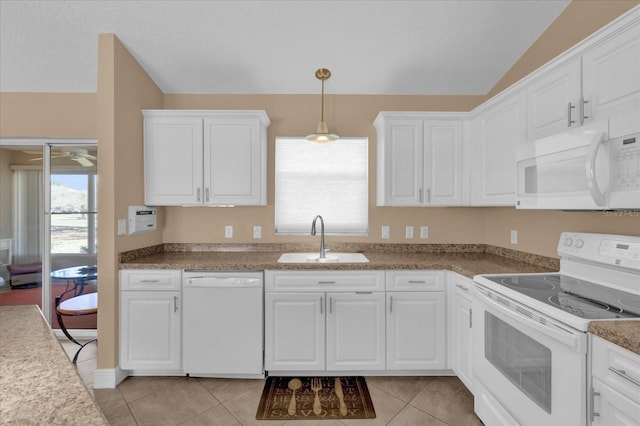 kitchen featuring lofted ceiling, white appliances, a sink, and light tile patterned floors