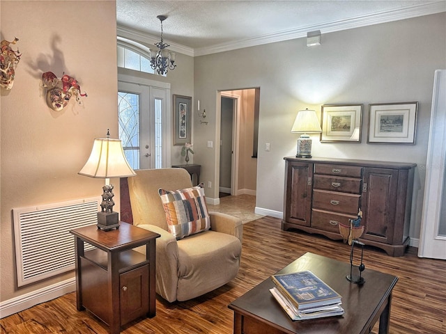 sitting room with visible vents, baseboards, ornamental molding, dark wood finished floors, and an inviting chandelier