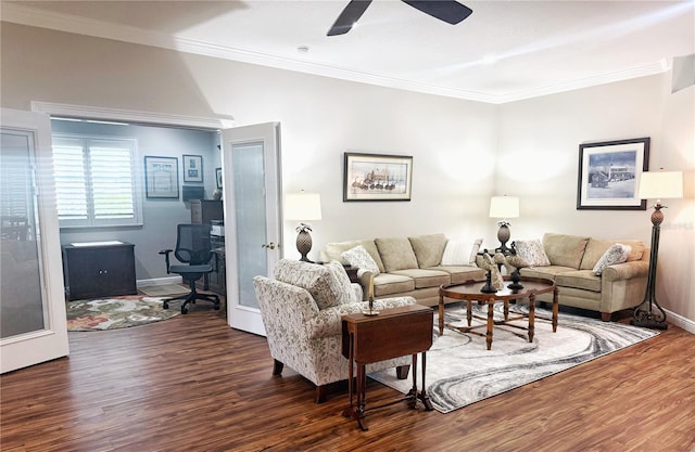 living area with baseboards, crown molding, a ceiling fan, and wood finished floors