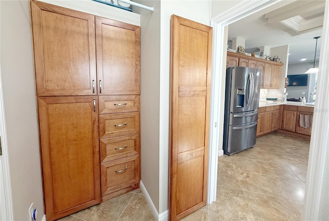 kitchen with baseboards, stainless steel refrigerator with ice dispenser, and light countertops