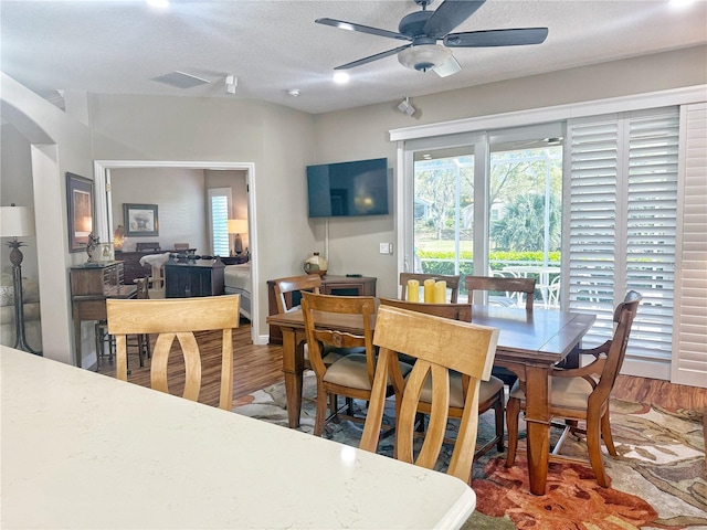 dining area with ceiling fan, a textured ceiling, wood finished floors, and visible vents