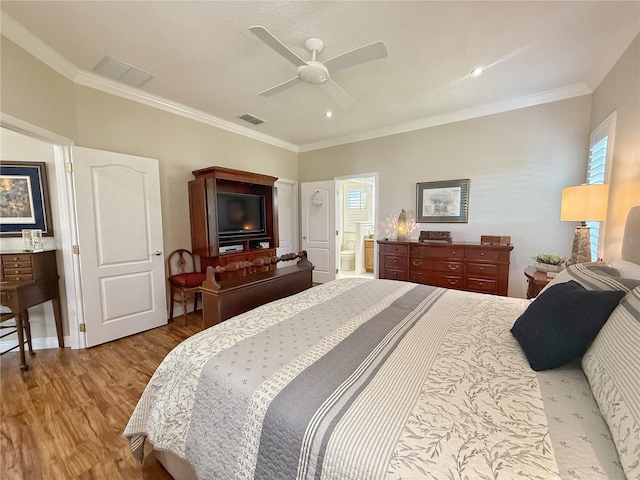 bedroom featuring crown molding, visible vents, ceiling fan, connected bathroom, and wood finished floors