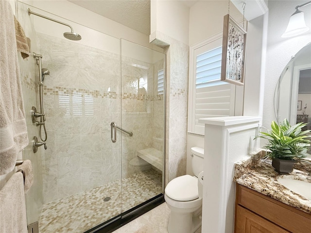 full bath featuring a stall shower, vanity, and toilet