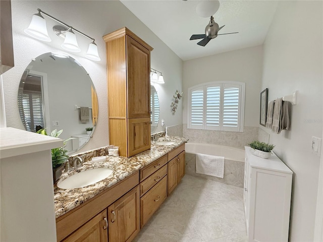 full bath featuring double vanity, a garden tub, ceiling fan, and a sink