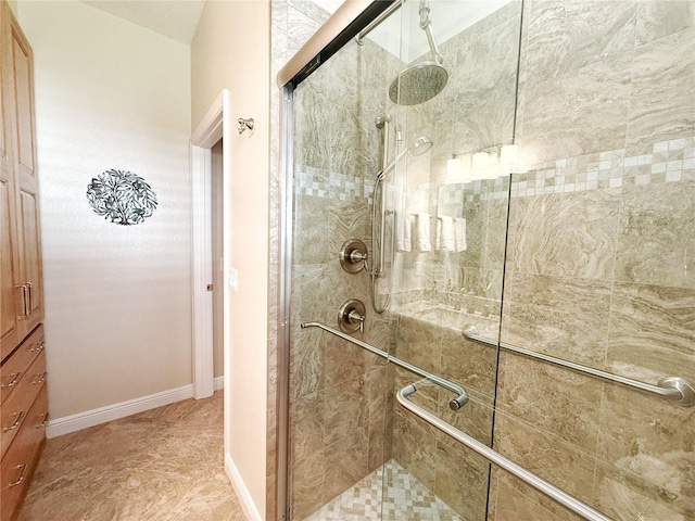 bathroom with a shower stall and baseboards