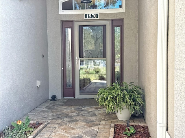 entrance to property featuring stucco siding