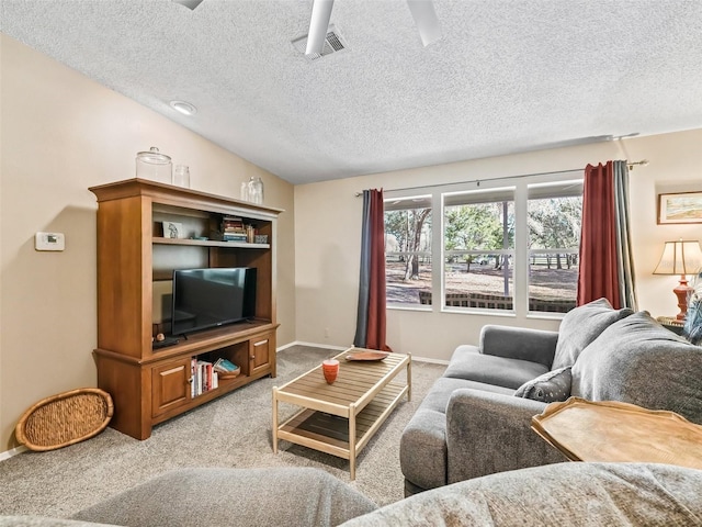 living area with ceiling fan, light carpet, visible vents, baseboards, and vaulted ceiling