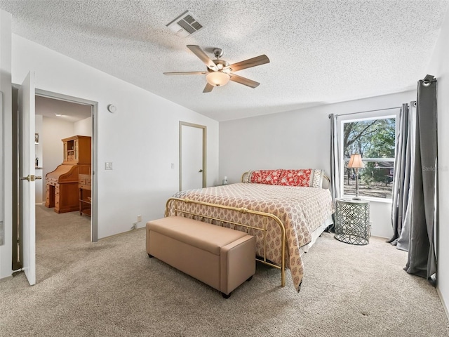 carpeted bedroom with ceiling fan, a textured ceiling, and visible vents