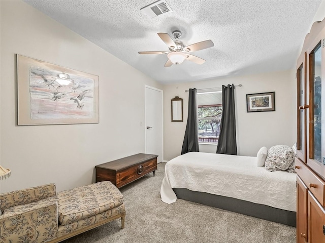 bedroom with a ceiling fan, visible vents, a textured ceiling, and carpet flooring