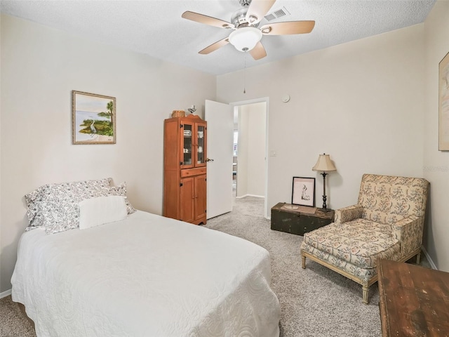 carpeted bedroom with ceiling fan, visible vents, and a textured ceiling