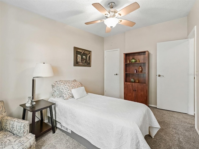 carpeted bedroom with a textured ceiling and ceiling fan