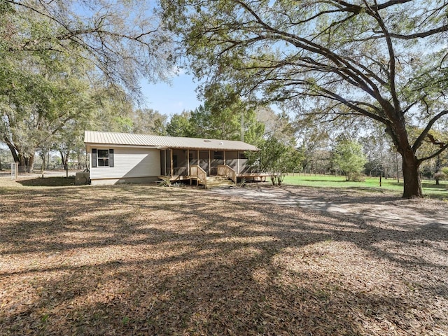 exterior space featuring metal roof and a sunroom