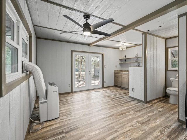 interior space with toilet, a ceiling fan, wood finished floors, and french doors