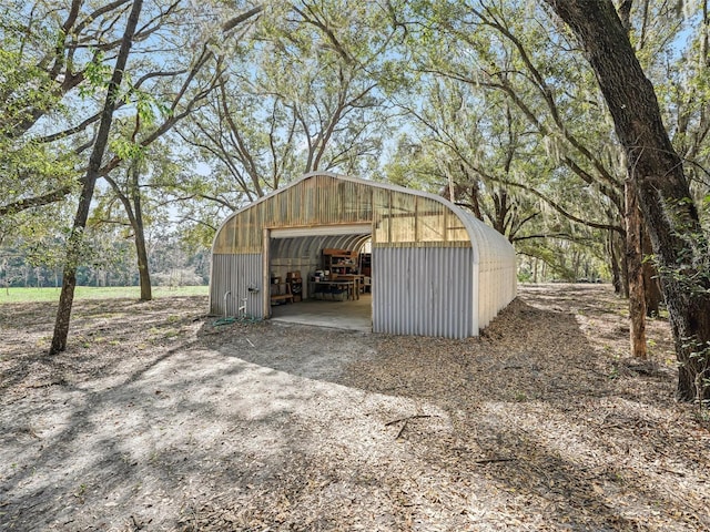 view of pole building with dirt driveway