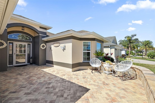 property entrance featuring stucco siding and a patio