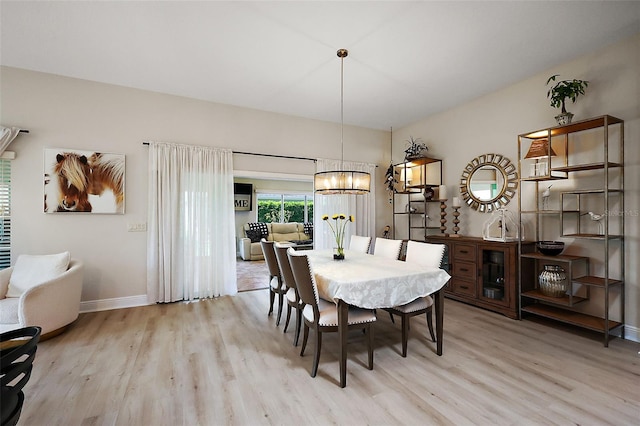 dining area with a notable chandelier, light wood-type flooring, and baseboards