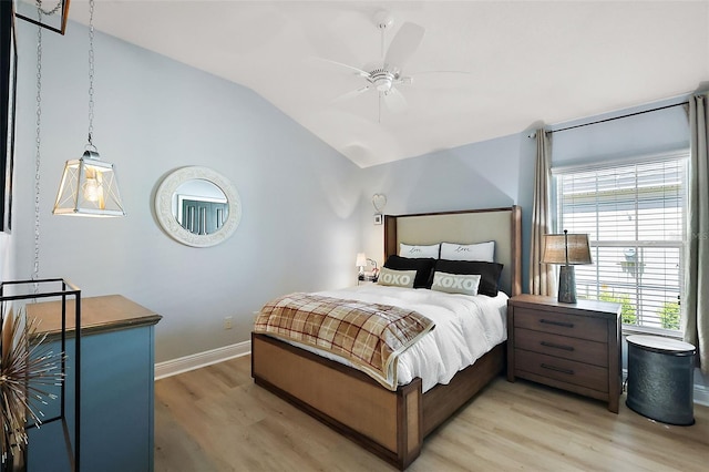 bedroom with vaulted ceiling, light wood-style floors, baseboards, and ceiling fan