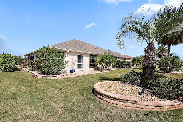 rear view of property with a patio area, a lawn, and stucco siding